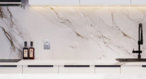 a silver top greener decorator receptacle with screwless wallplate in a marble walled kitchen